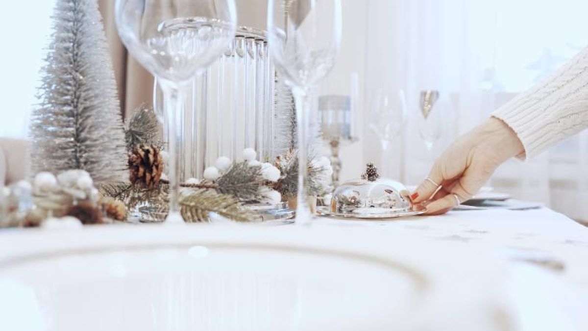 Mesa navideña con decoración blanca.