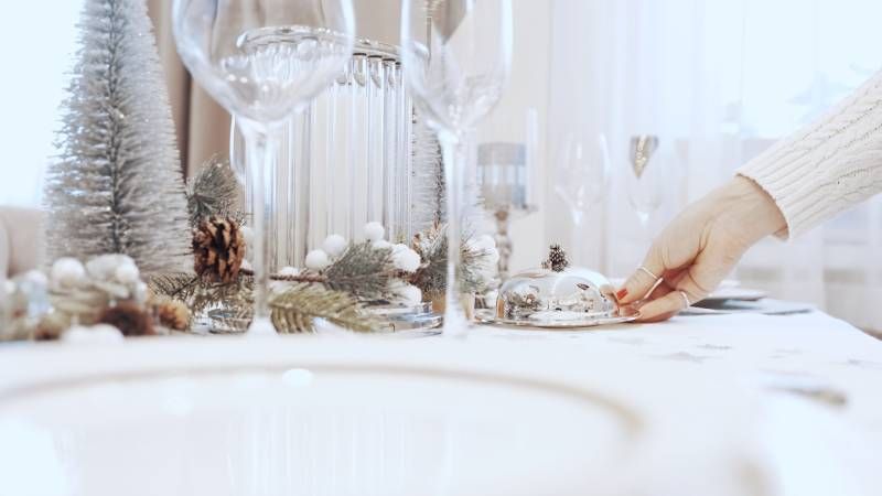 Mesa navideña con decoración blanca.