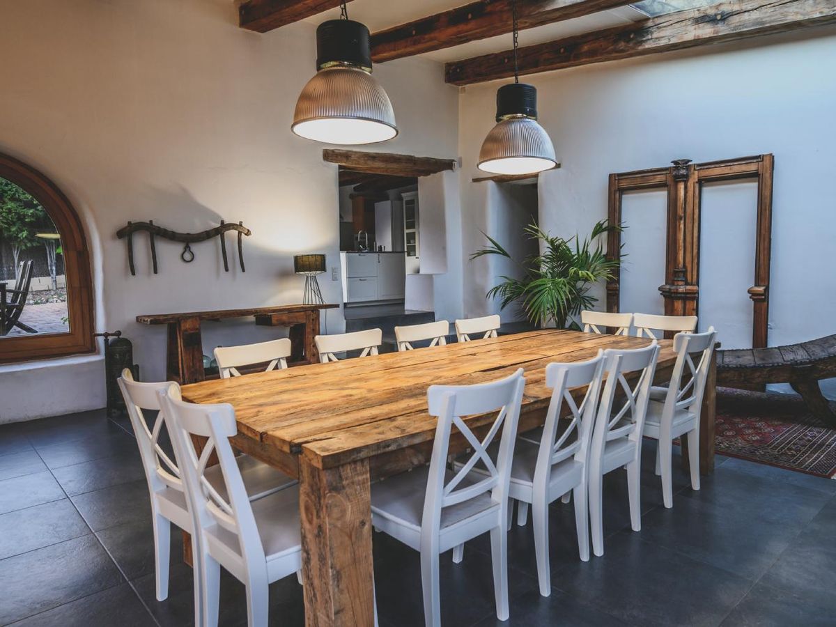 Comedor con mesa rectangular de madera de estilo rústico.