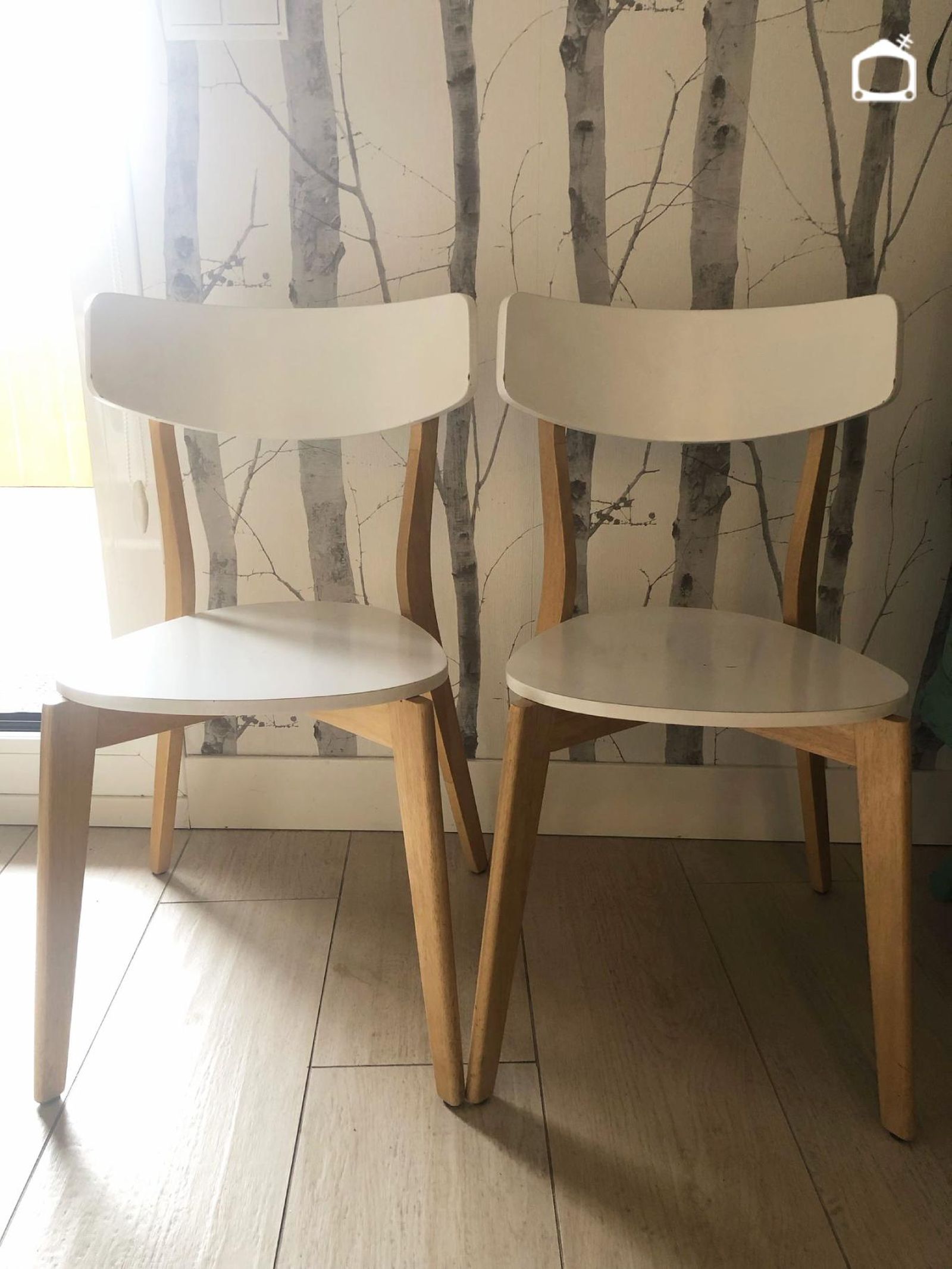 Silla con pata de madera reparada junto a otra de la colección.
