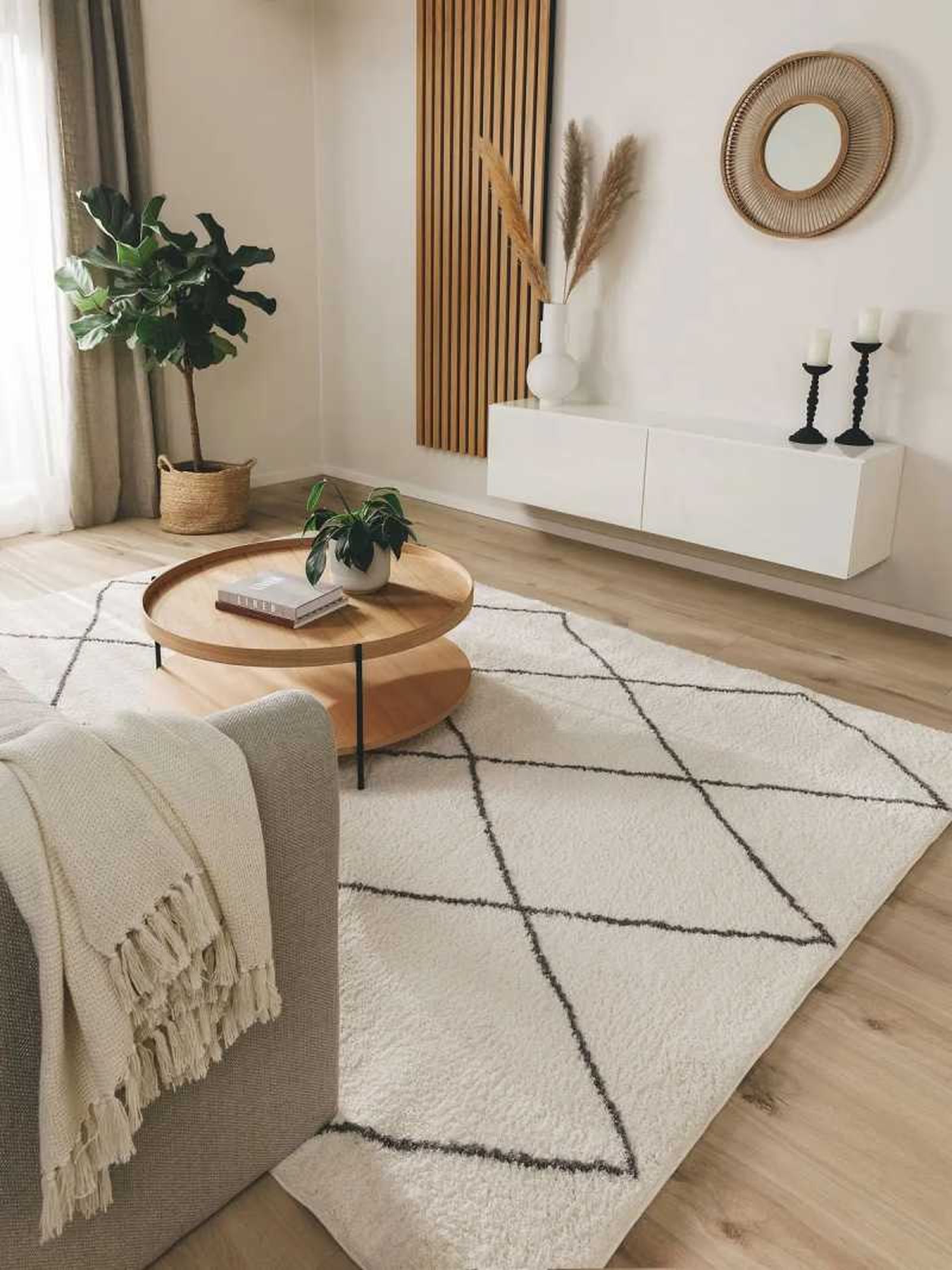Salón beige con alfombra de estampado geométrico.