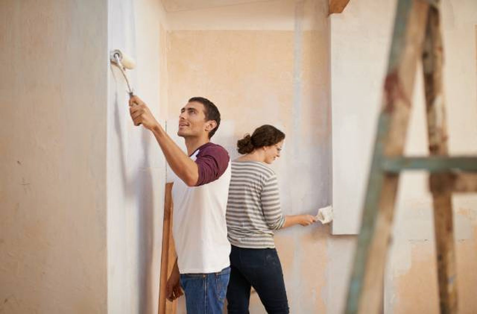 pareja pintando casa