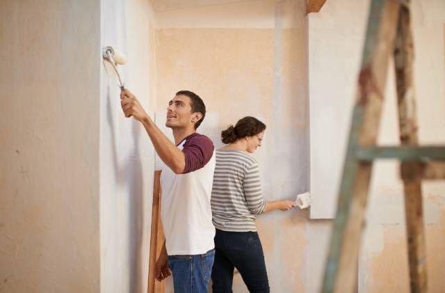 pareja pintando casa
