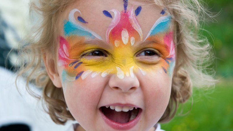 Maquillaje facial de mariposa con los colores del arcoíris