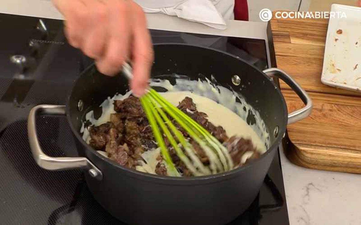 Mezcla la bechamel con el rabo de ternera desmigado