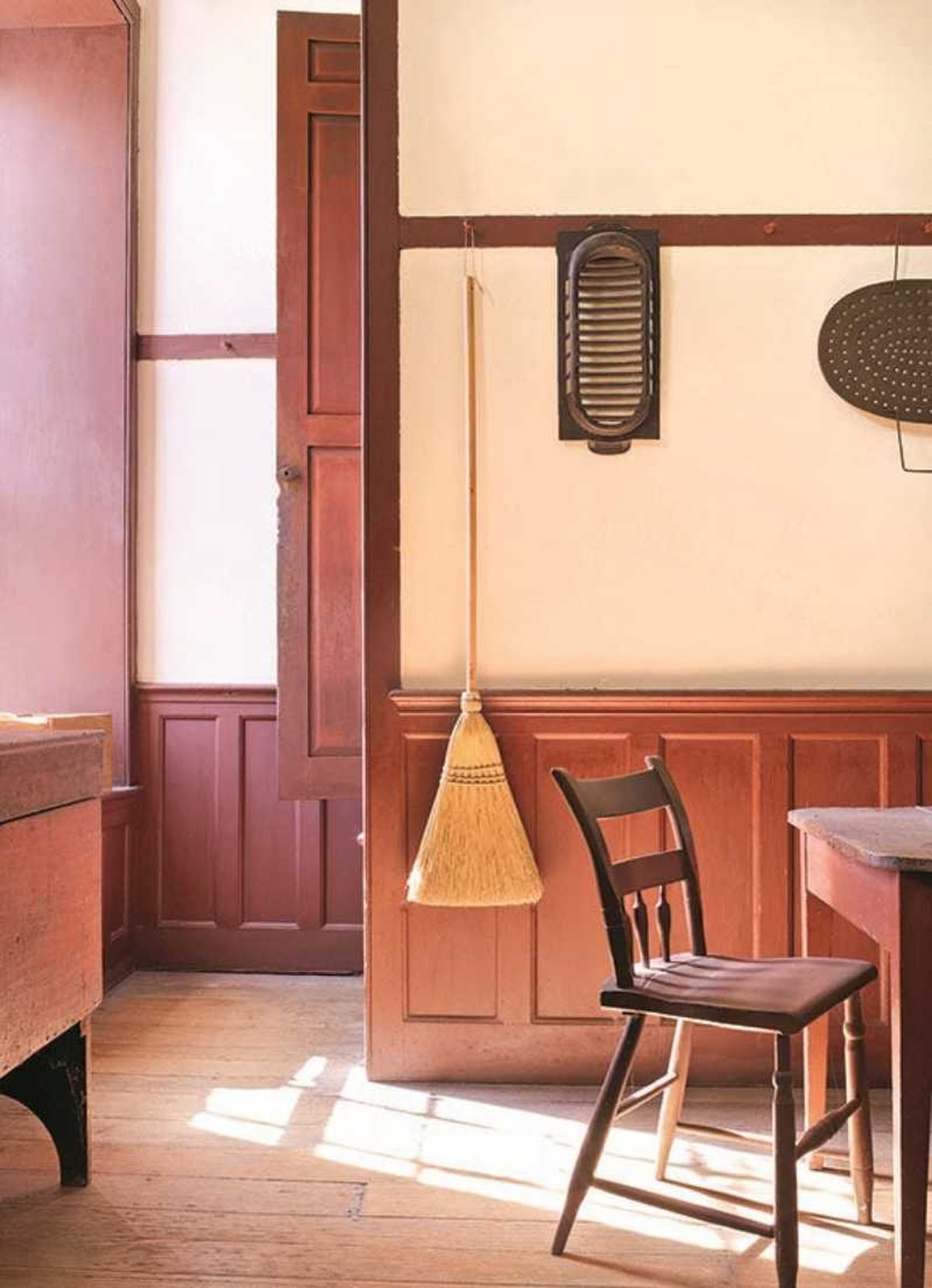 Comedor de madera con escoba colgada de la pared.