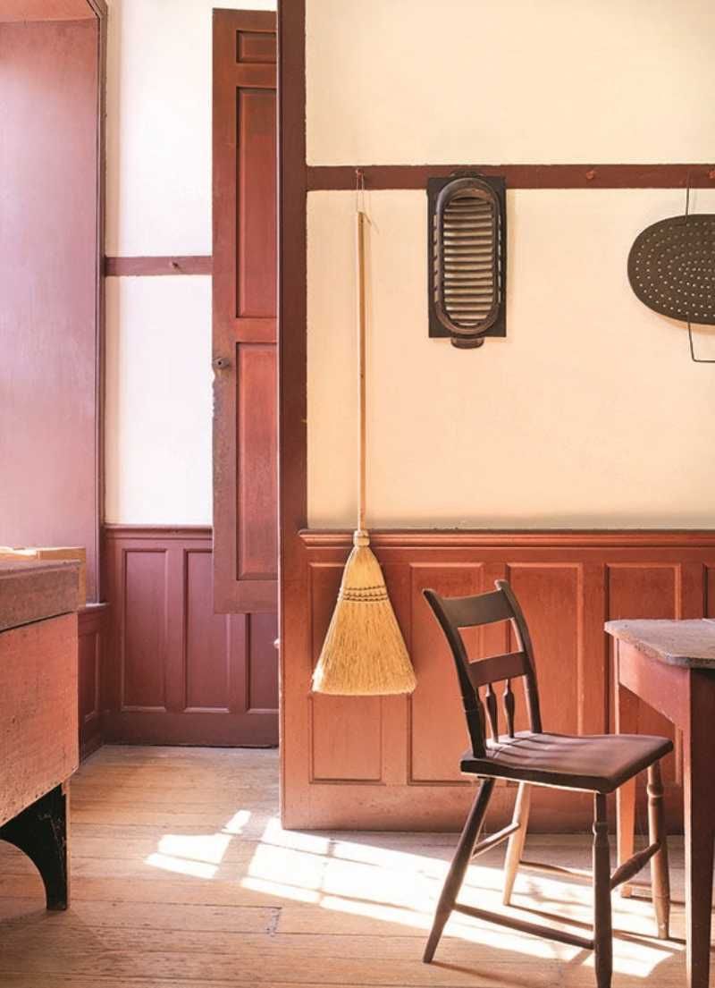Comedor de madera con escoba colgada de la pared.