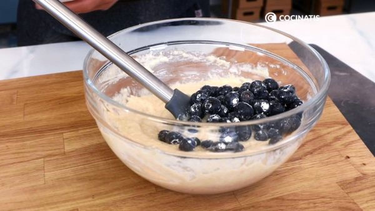 Añade los arándanos enharinados a la masa de bizcocho