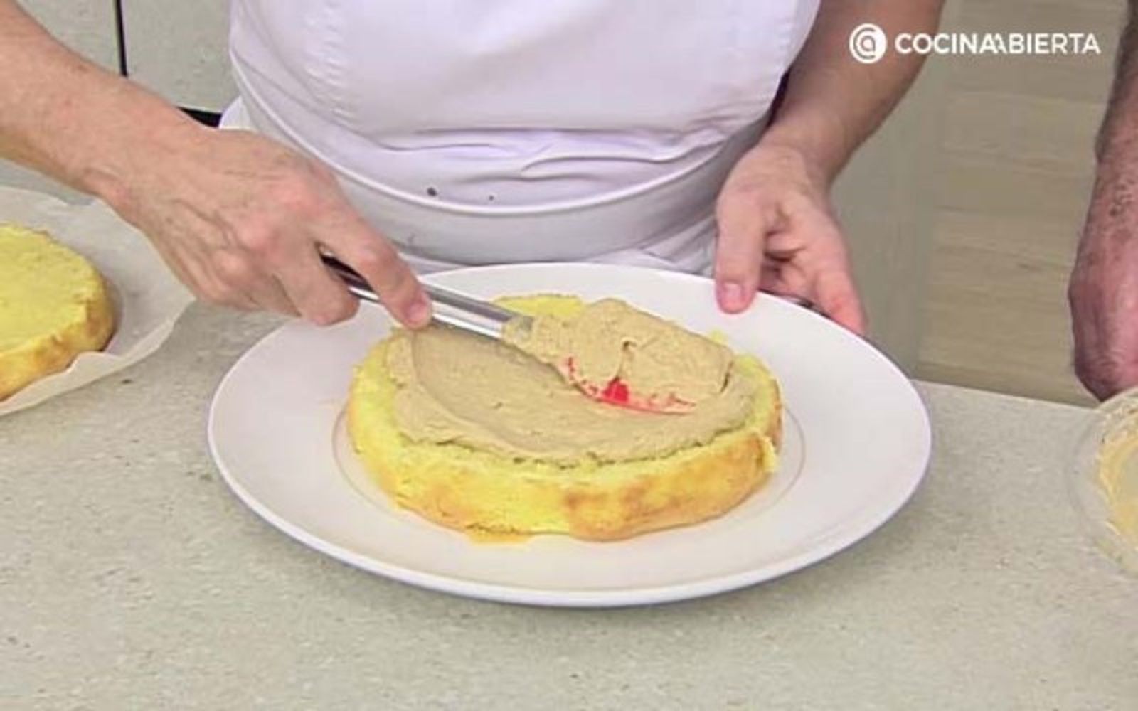 Extiende la crema de moka por todo el bizcocho, incluyendo los laterales