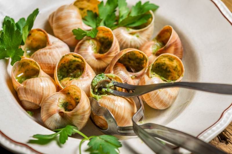 Plato típico de caracoles con mantequilla, ajo y perejil