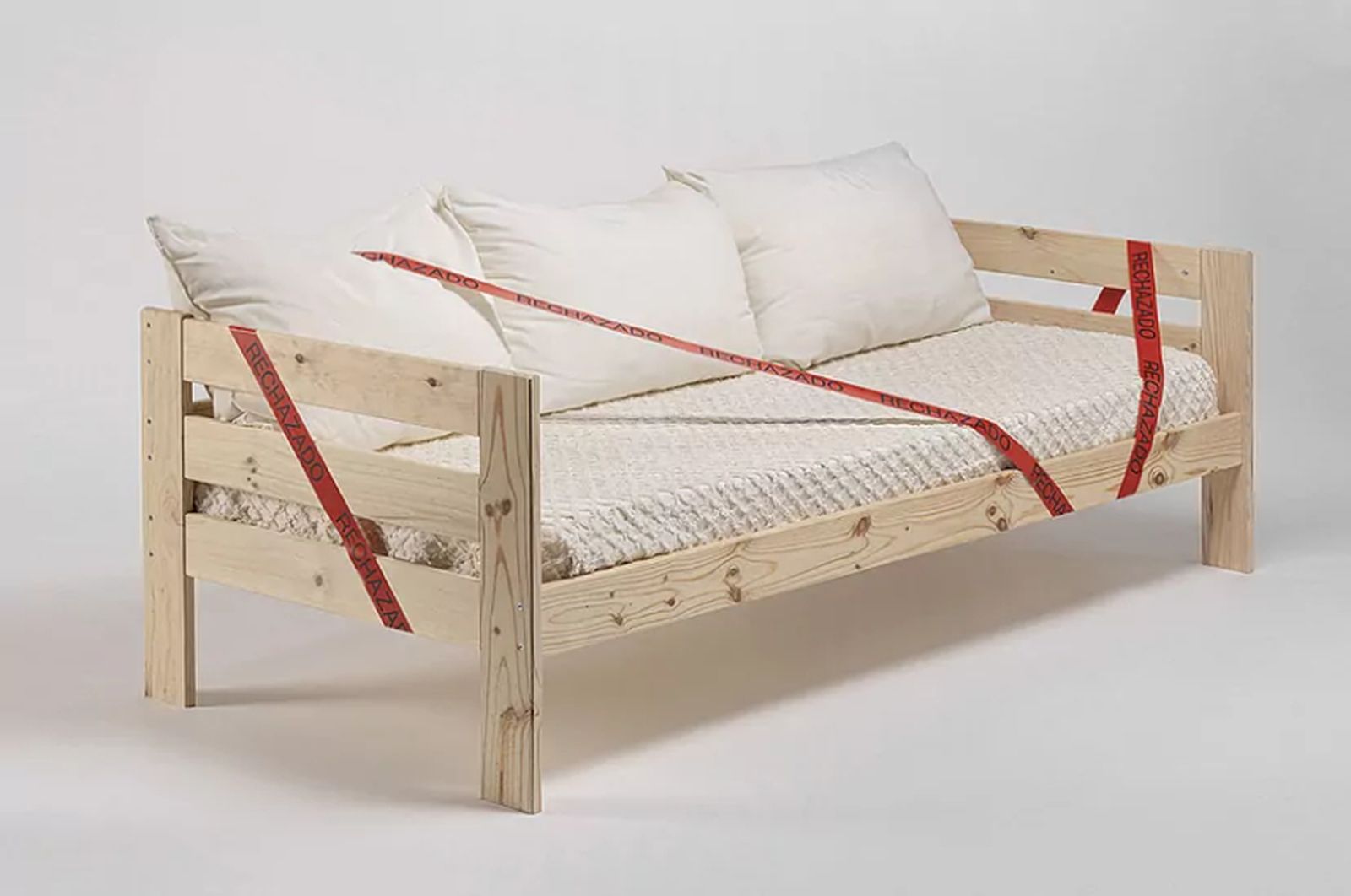 Sofá de madera con precinto de rechazado, de la campaña de muebles feos.