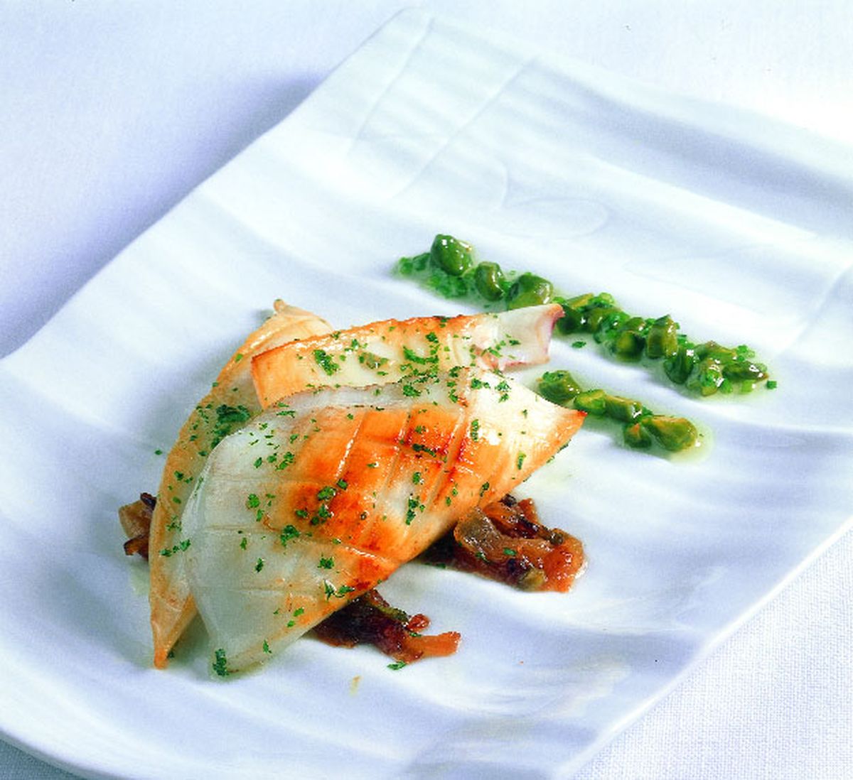 Calamar grande a la plancha y encebollado con vinagreta de cebollino y pistachos