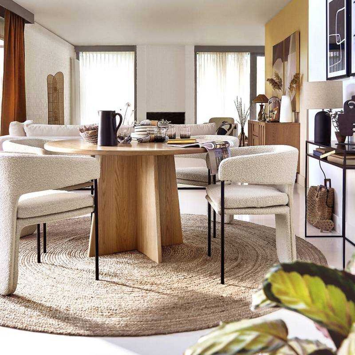 Salón comedor con mesa de madera y sillas de borreguito.