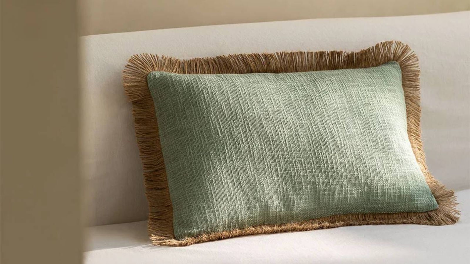 Cojín rectangular verde con flecos de fibras naturales. / Sklum