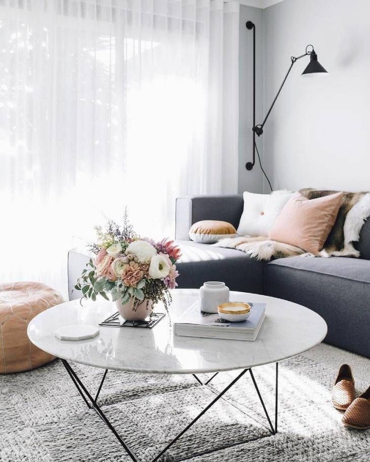 Salón elegante con mesa de centro decorada con flores y otros adornos.