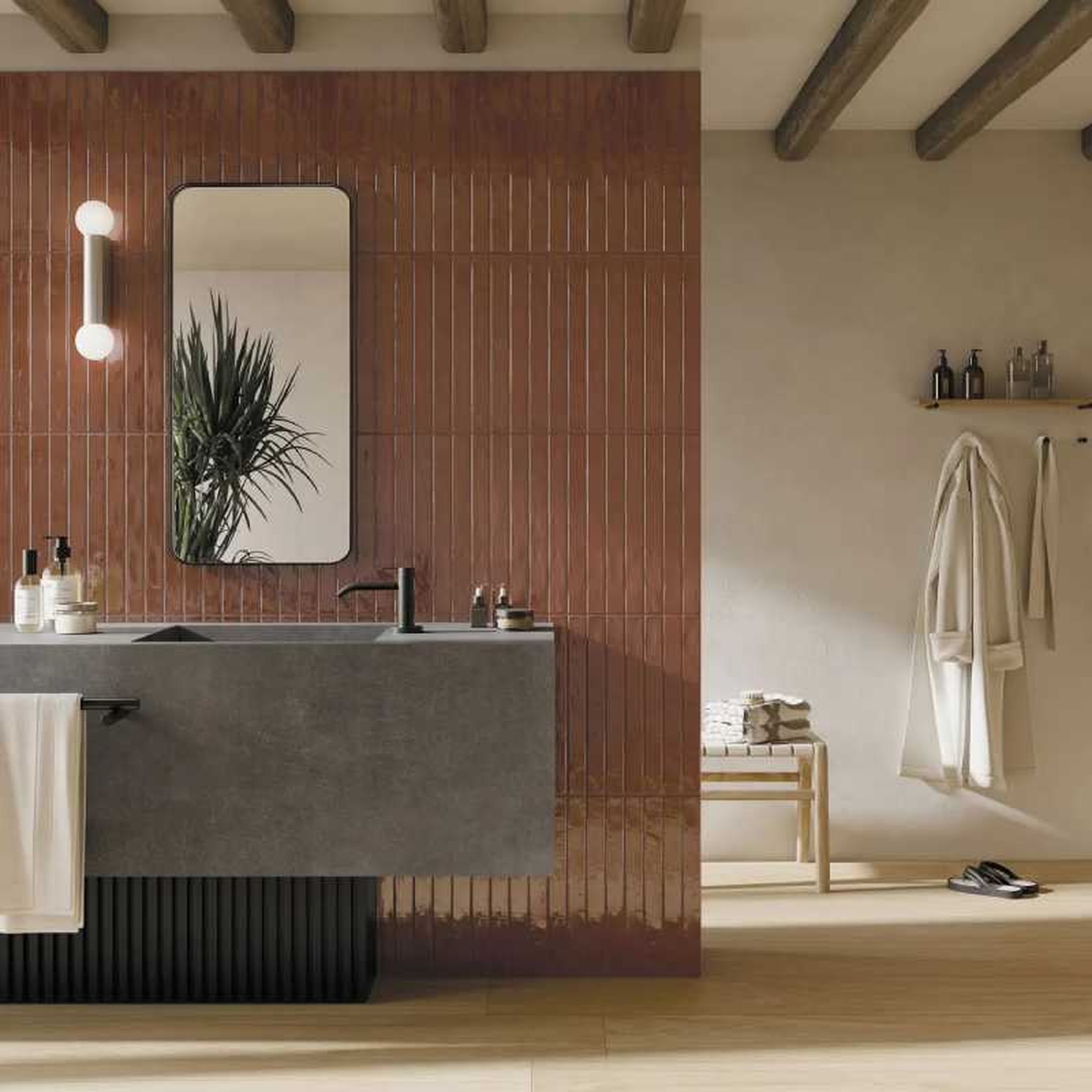 Baño con azulejos marrones alargados.