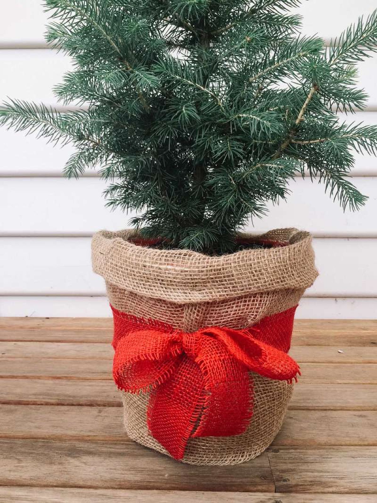 Árbol de Navidad con cesta tipo saco de fibras naturales.