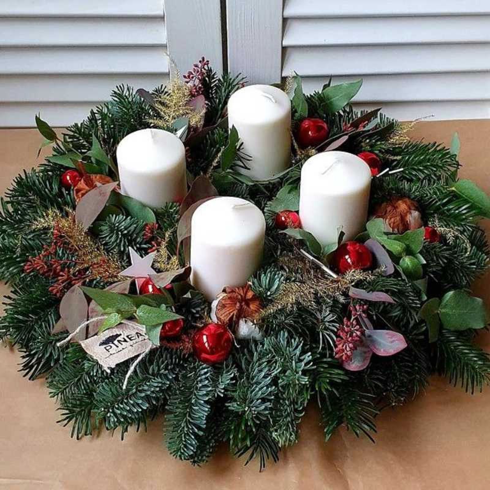 Corona de Navidad con velas en la ventana.