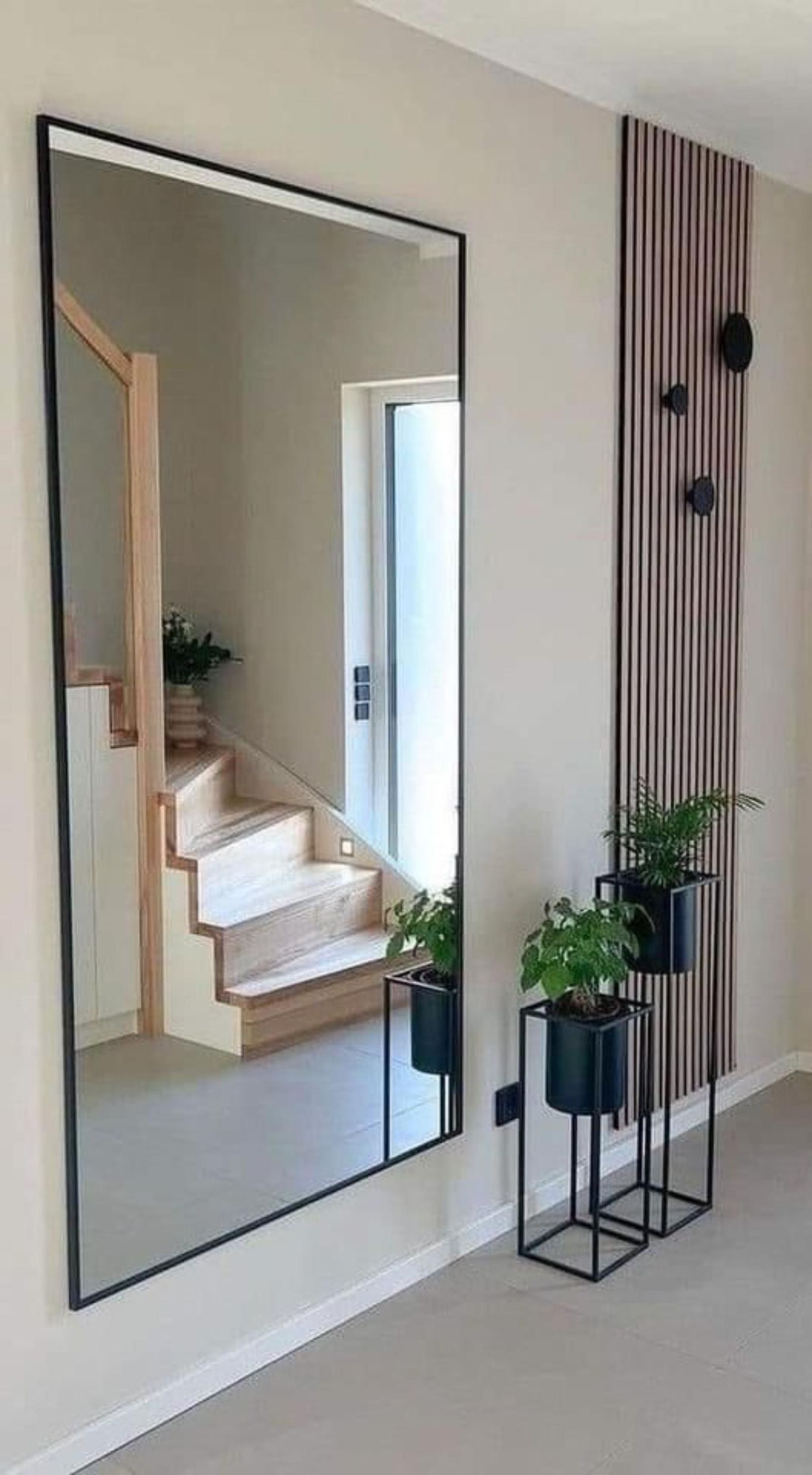 Recibidor con espejo grande de pared de estilo industrial.