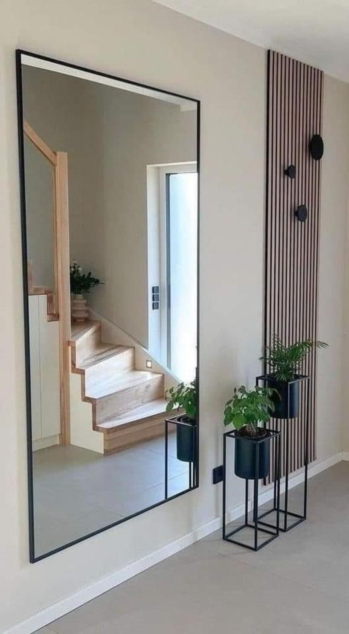 Recibidor con espejo grande de pared de estilo industrial.