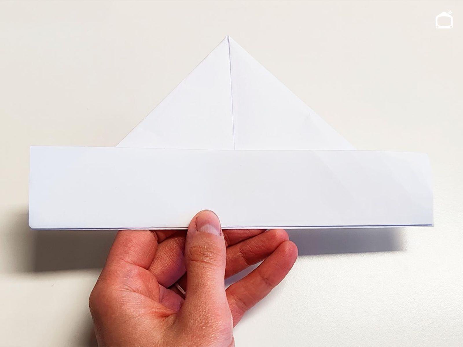Tercer paso para hacer un barco de papel.