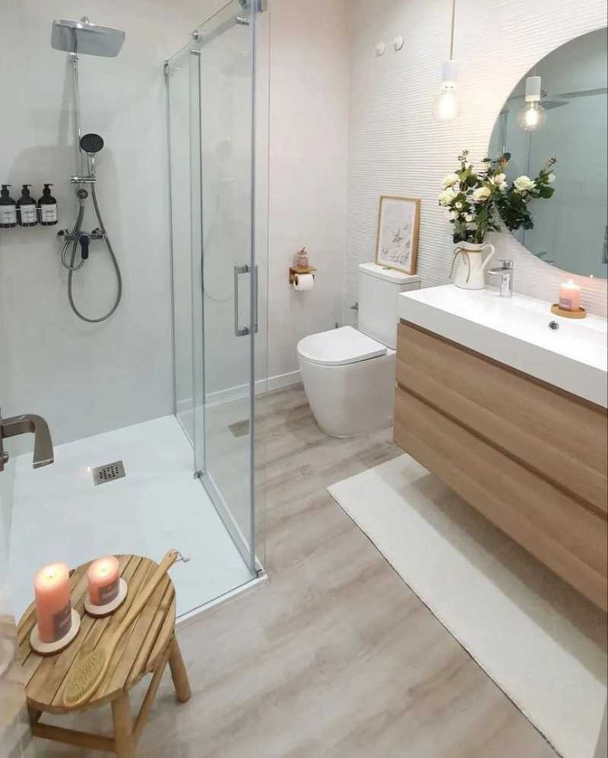 Baño blanco con suelo de madera.