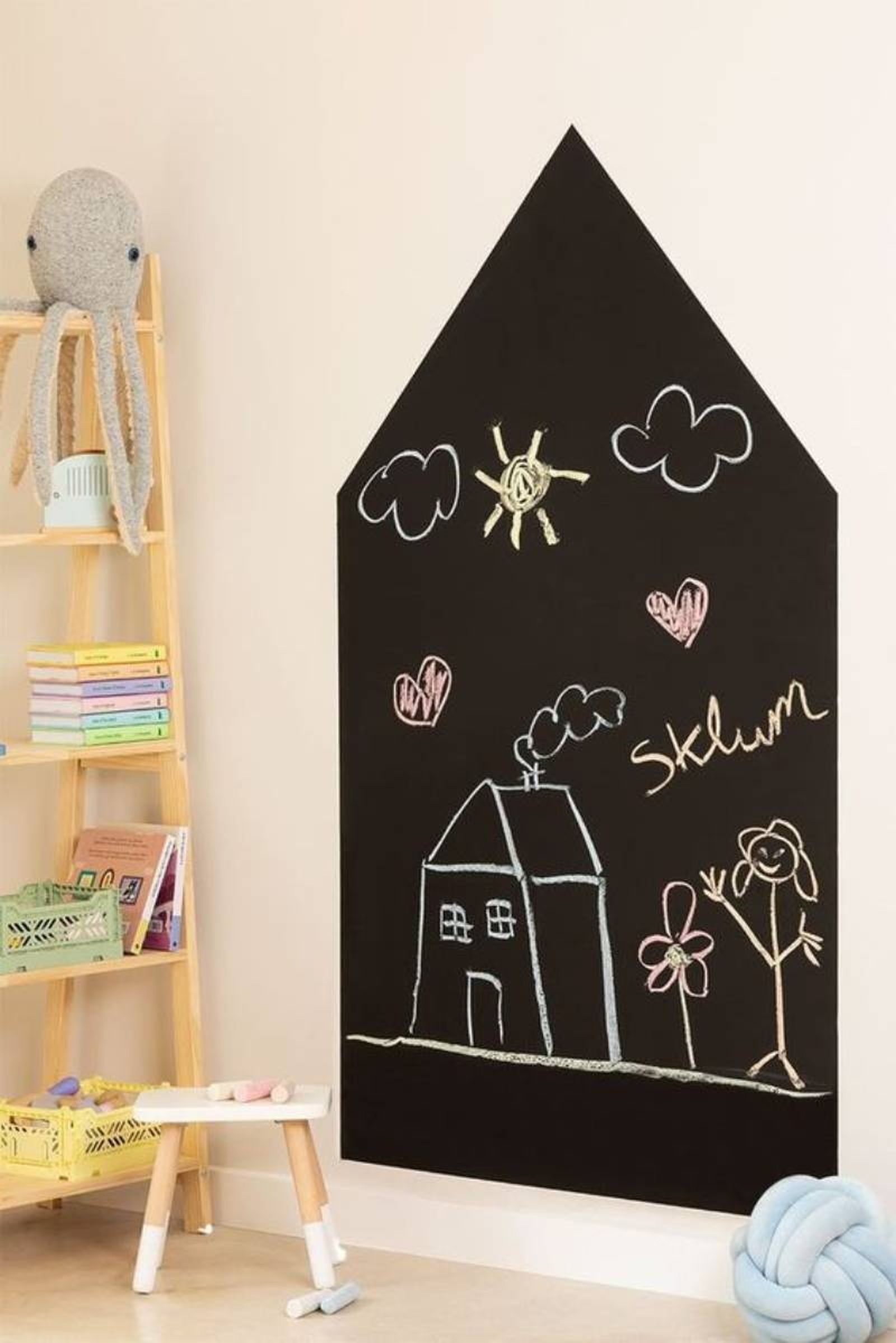 Pizarra con forma de casita en la pared.