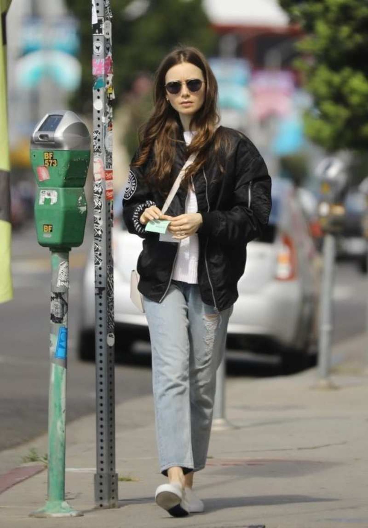 Lily Collins con vaqueros y bomber