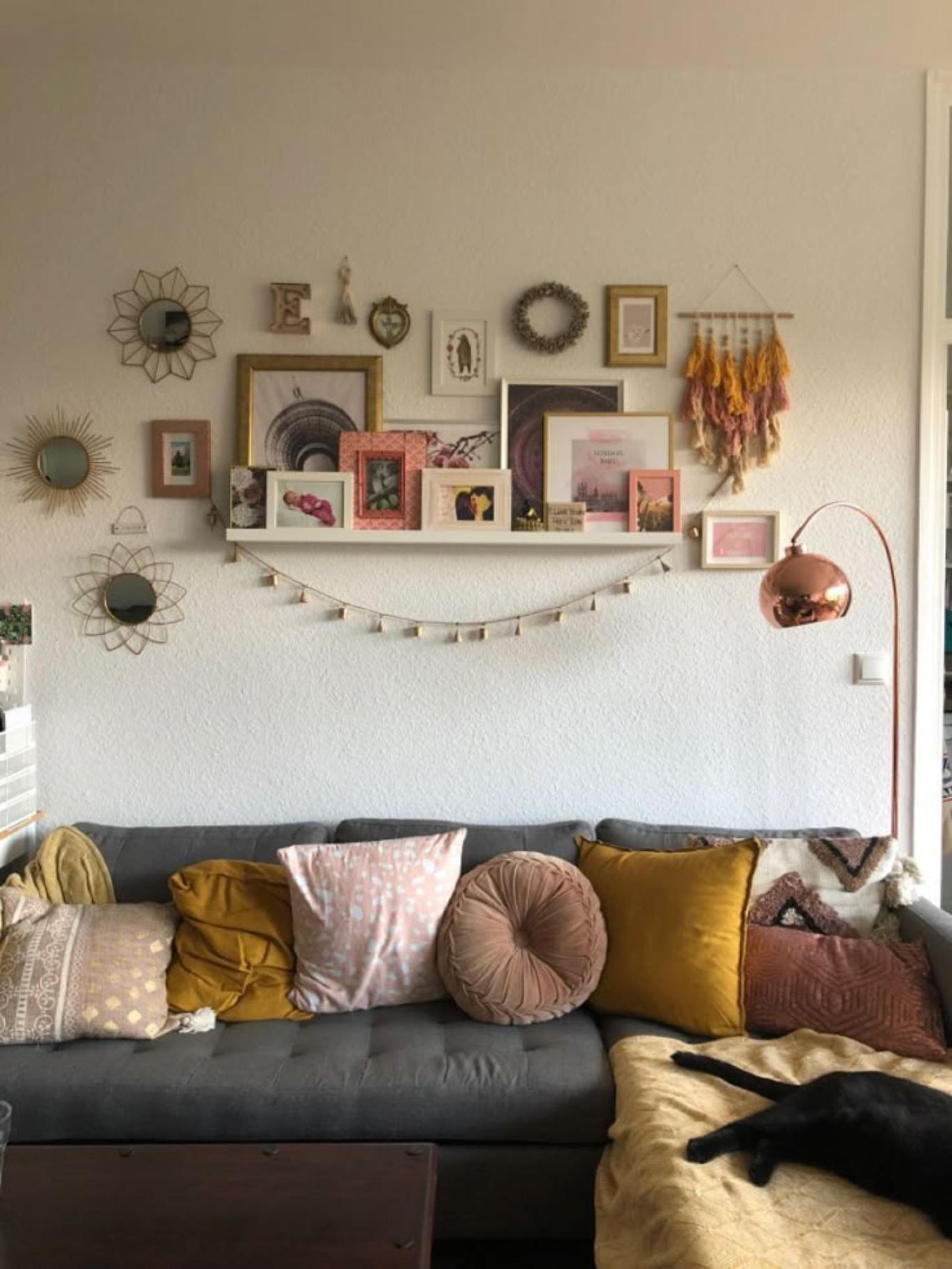 Salón con sofá gris con cojines con formas inusuales.