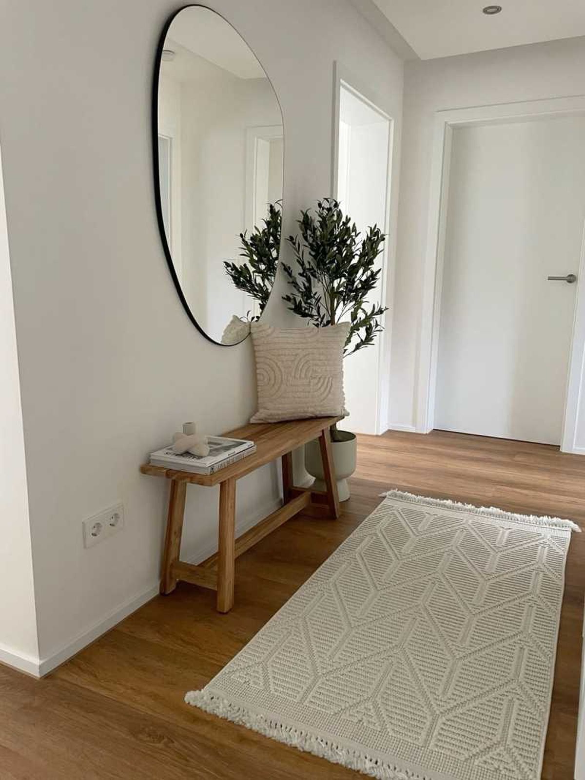 Recibidor minimalista con alfombra beige.