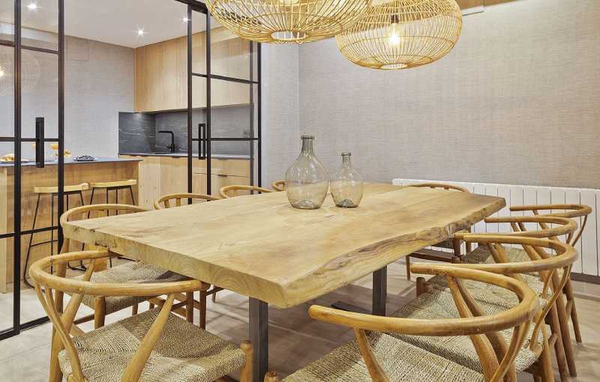 Comedor con muebles de madera y lámparas de fibras naturales.