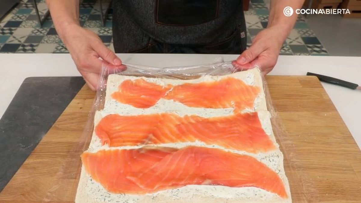 Añade salmón ahumado sobre el queso crema y enrolla