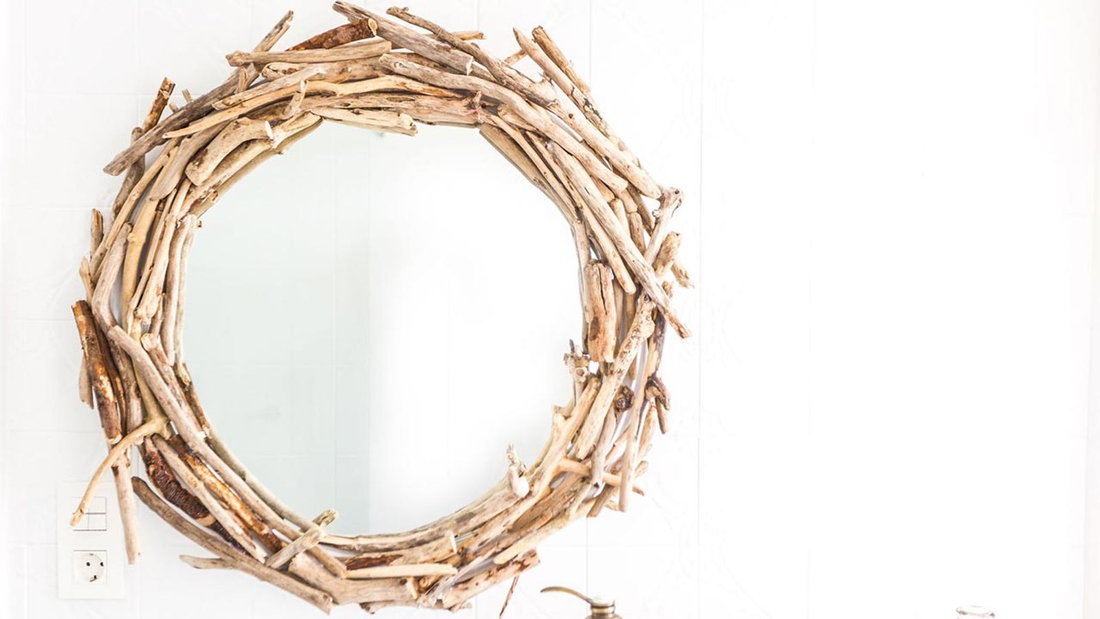 Espejo con ramas para decorar el baño.