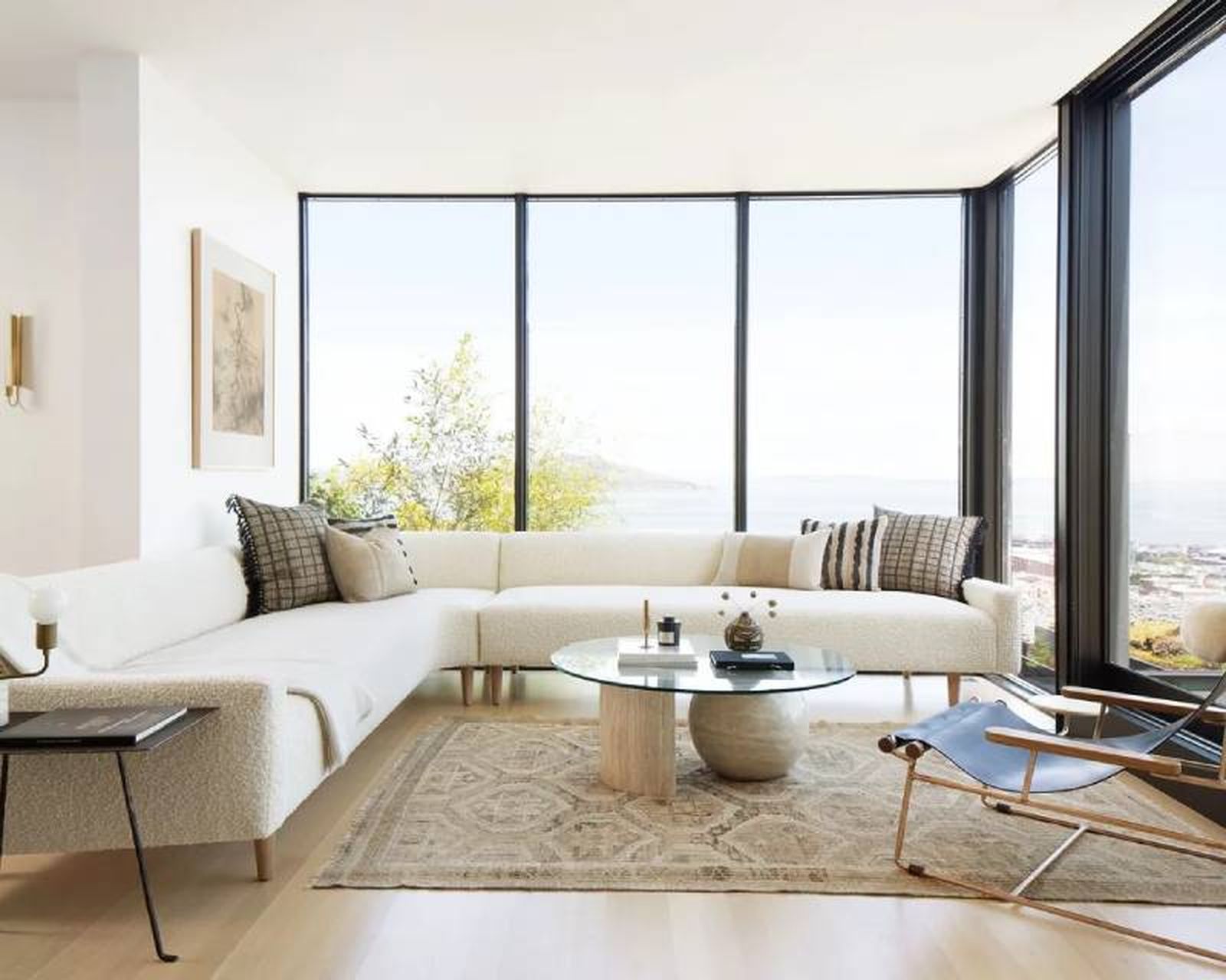 Salón con ventanal decorado en tonos claros y de estilo minimalista.