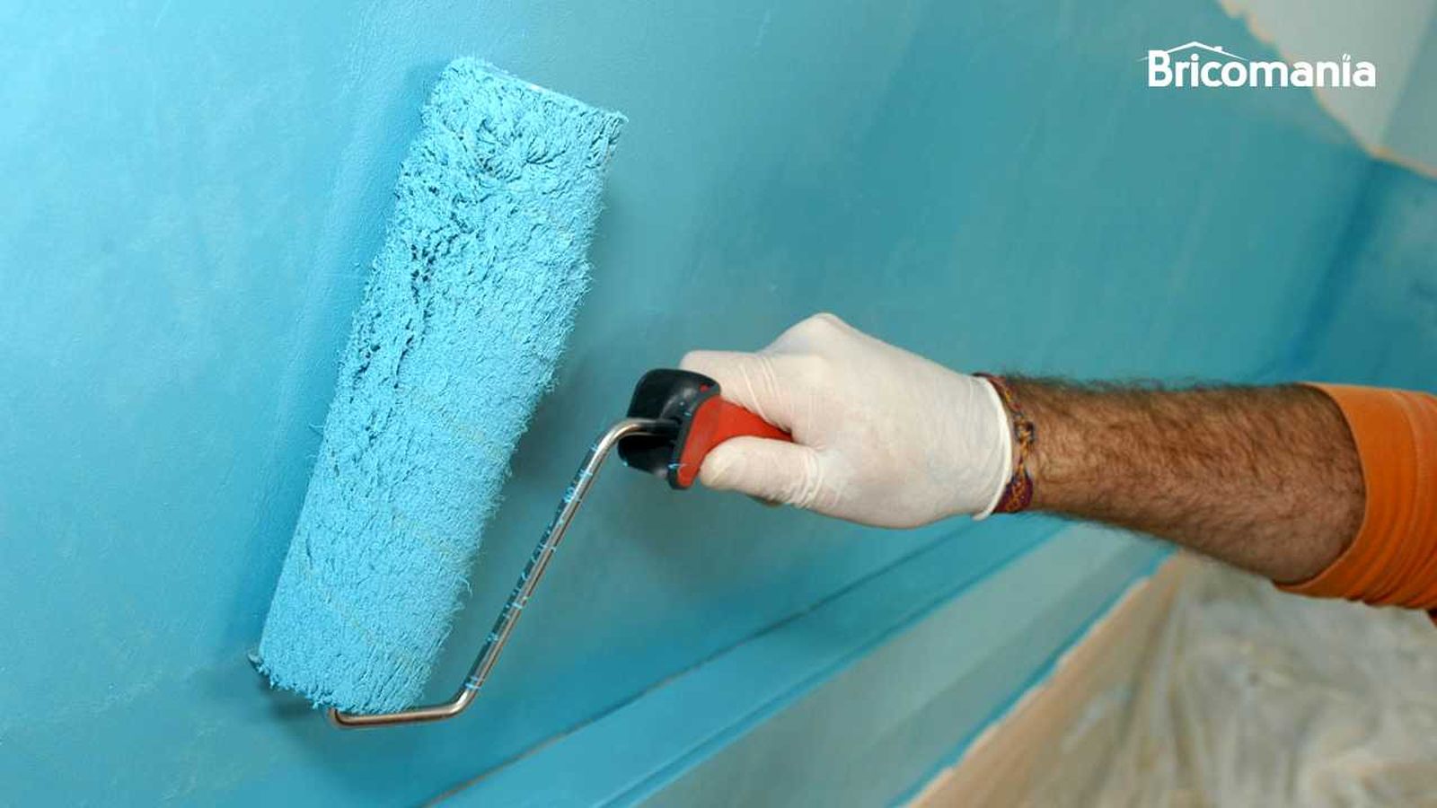 Persona pintando una pared con un rodillo