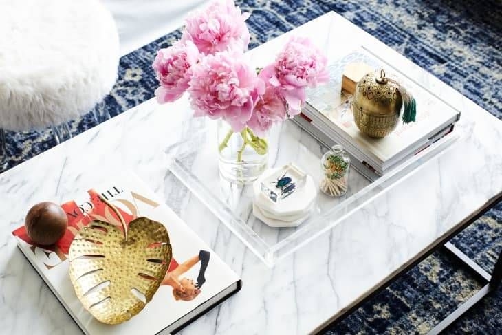 Mesa de centro con flores y adornos dorados.