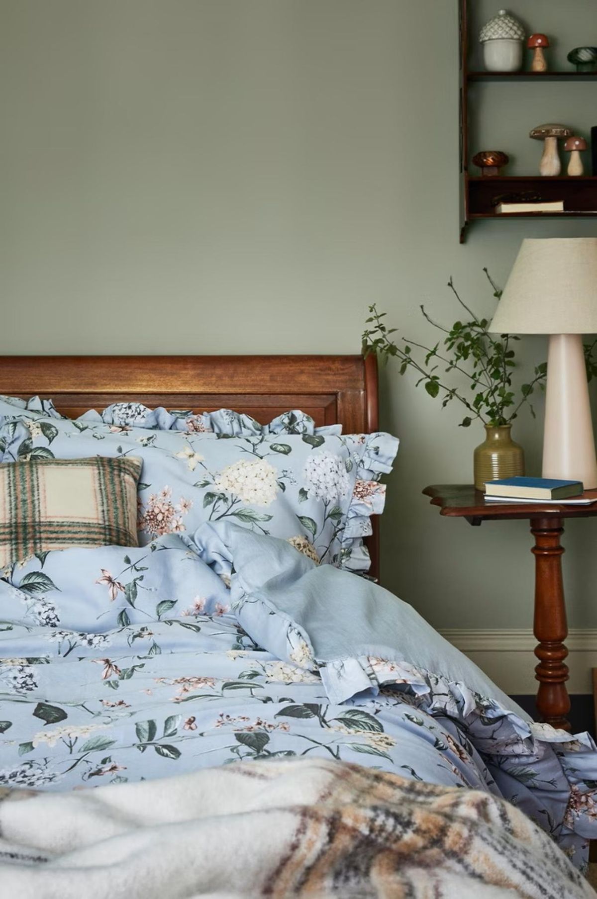 Dormitorio con colcha florar de estilo cabincore.