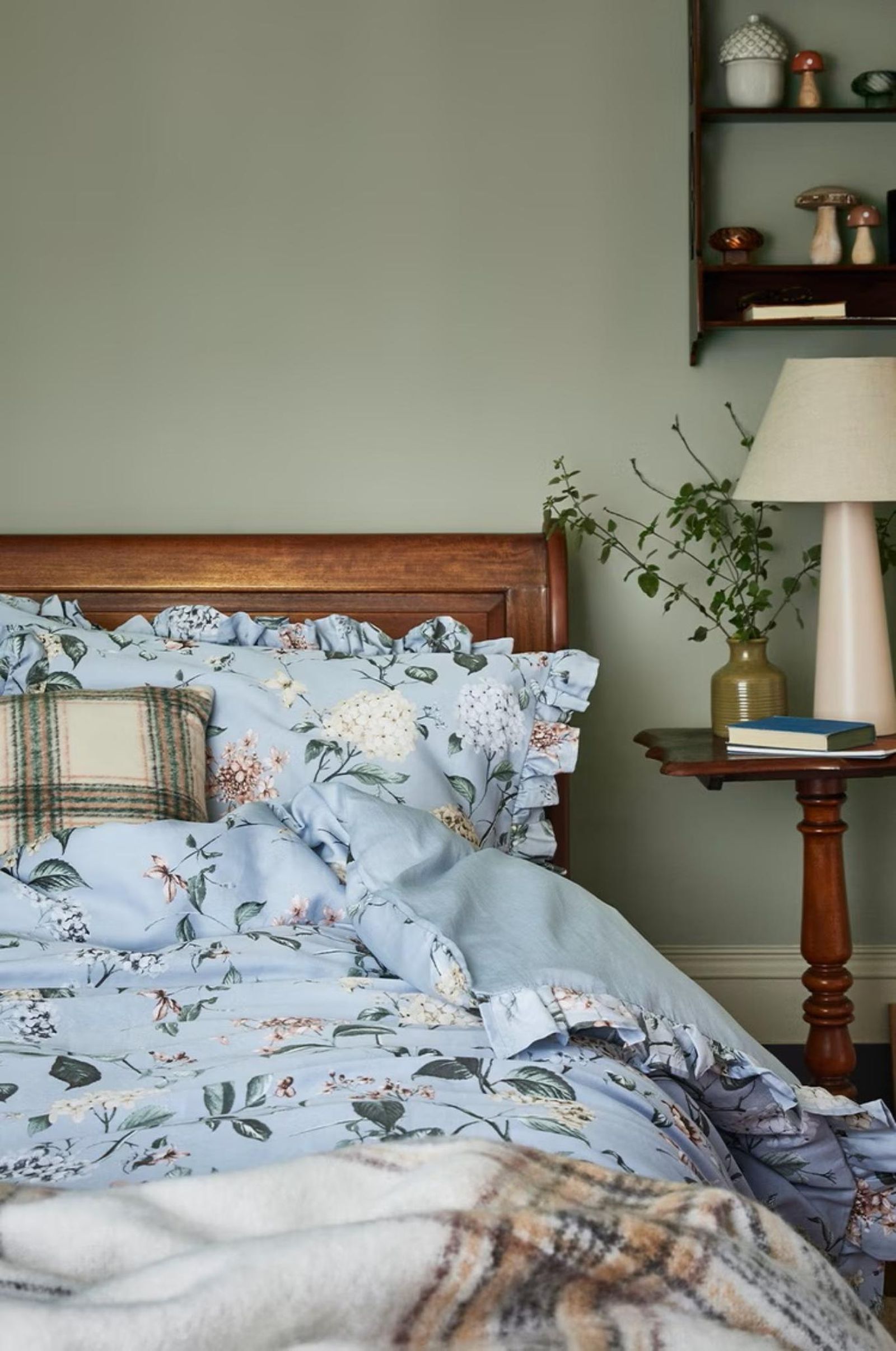 Dormitorio con colcha florar de estilo cabincore.