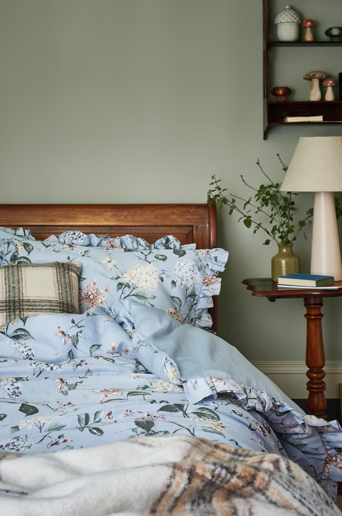 Dormitorio con colcha florar de estilo cabincore.