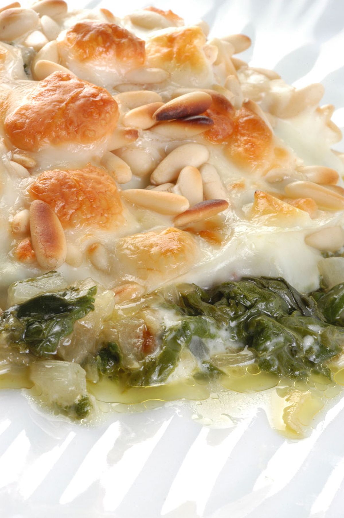 Acelgas gratinadas con queso y piñones