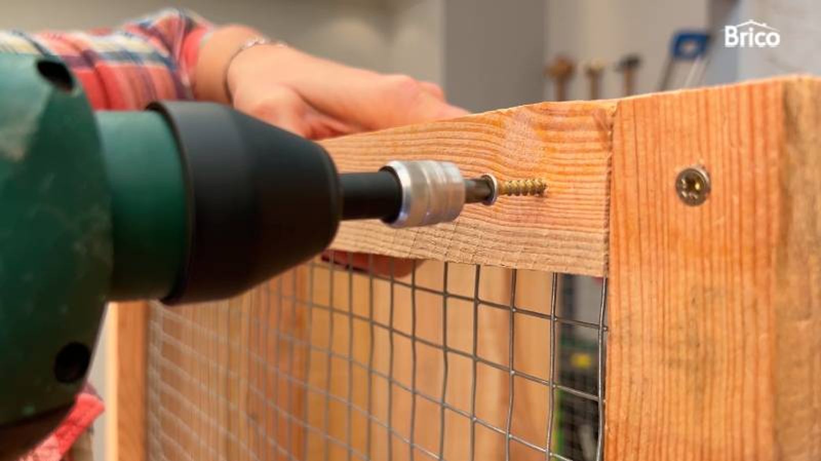 Persona fijando un tirafondo en madera