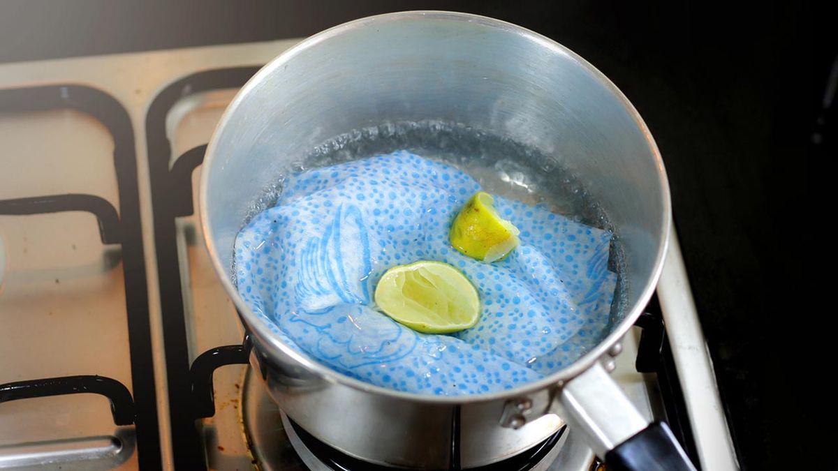 Trapos de cocina sucios en una cazuela con vinagre y limón, tratamiento contra manchas de grasa