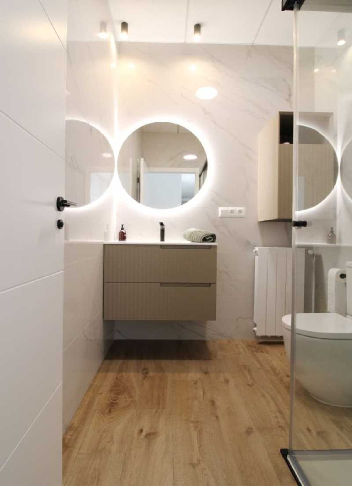 Baño con azulejos de imitación a madera.