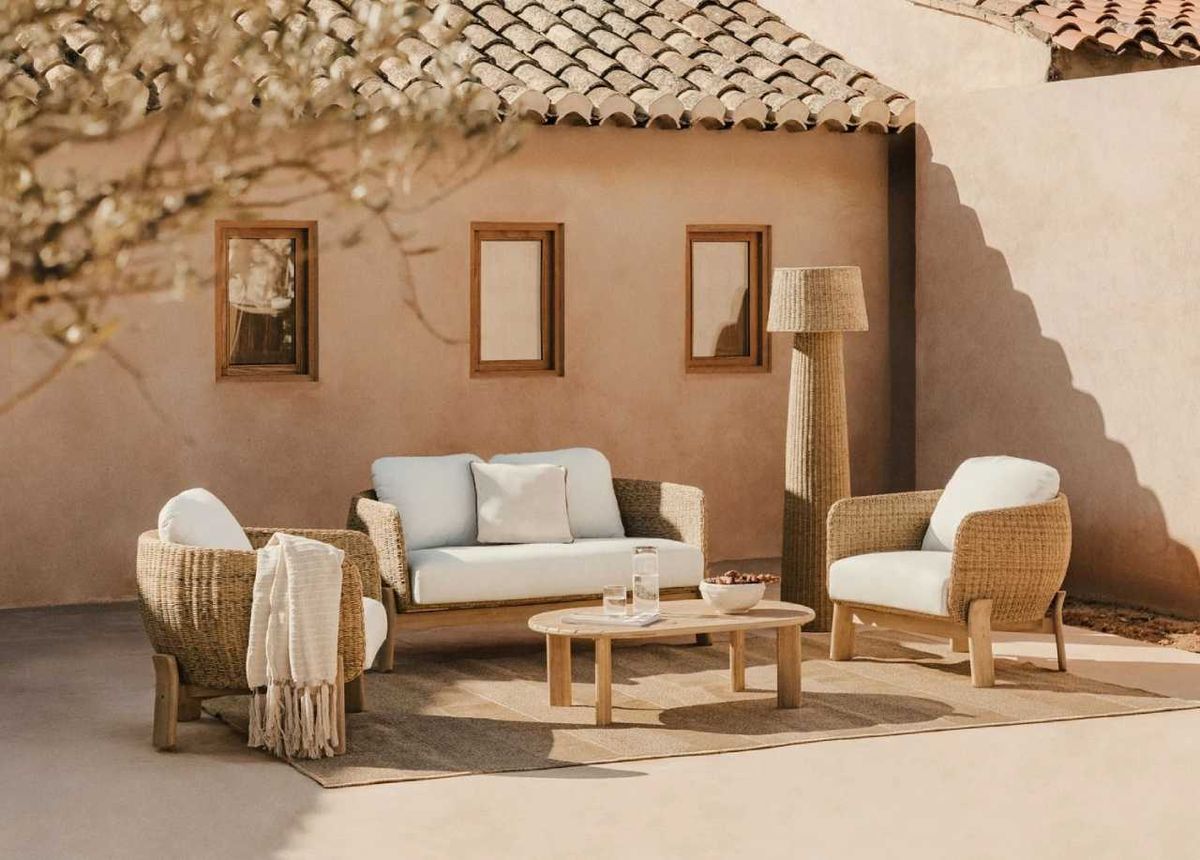Patio acogedor de una casa de pueblo con muebles de exterior de madera y fibras naturales de la nueva colección.