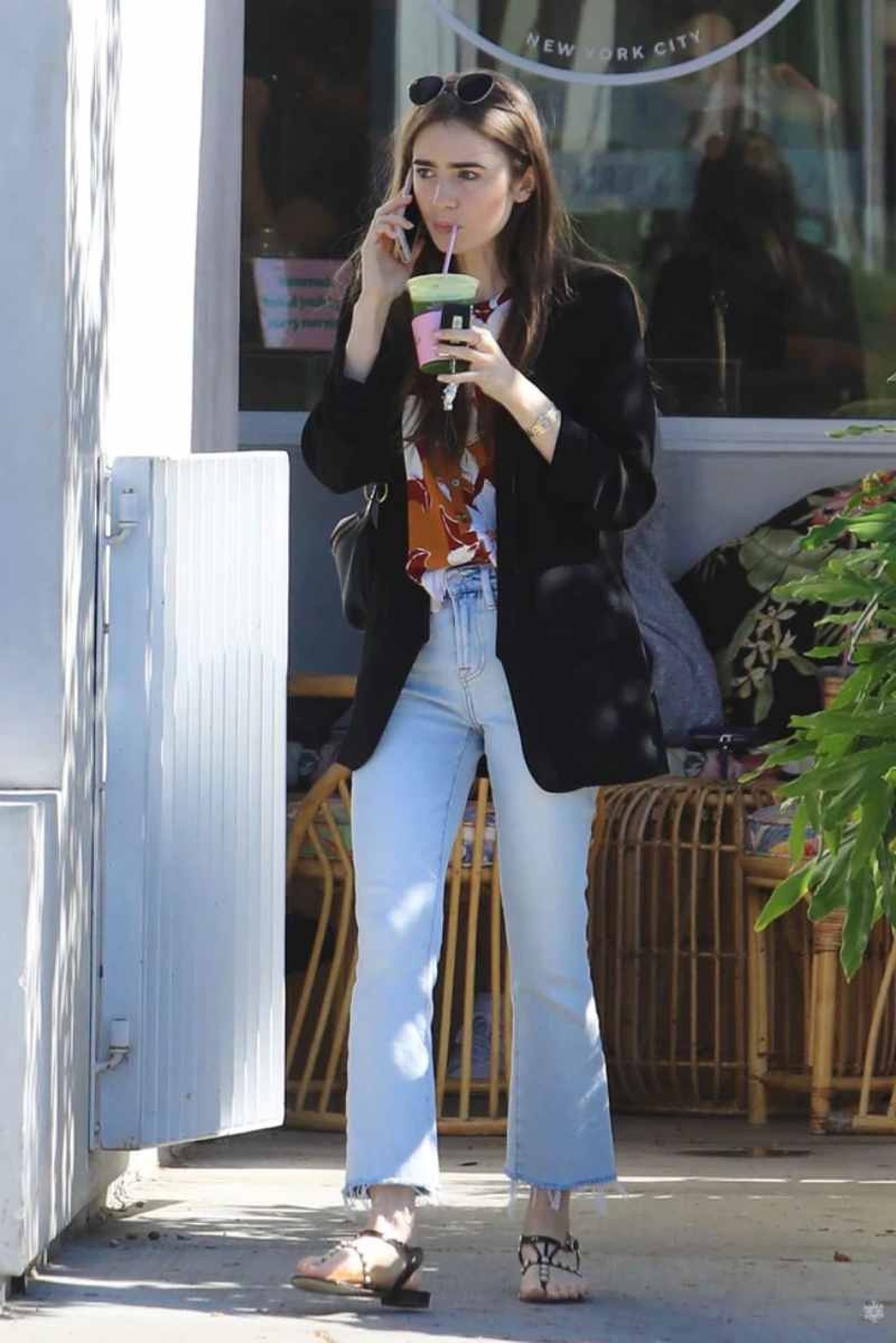Lily Collins con vaqueros, blazer y sandalias planas