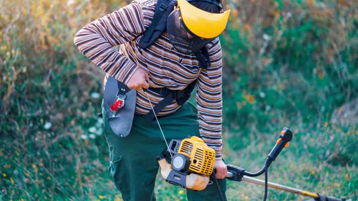 Persona intentando arrancar una desbrozadora