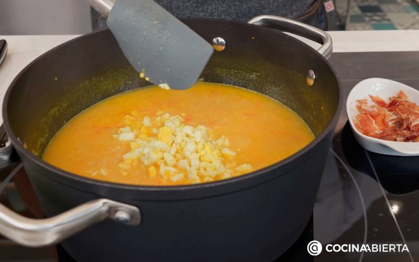 Elaboración de la receta de sopa con virutas de jamón - Añade el huevo cocido y el jamón ibérico