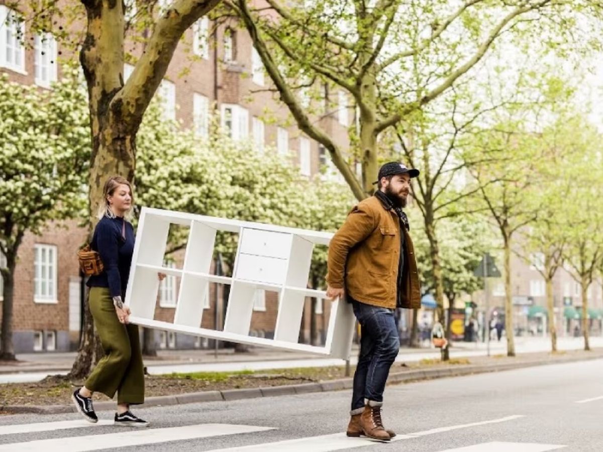 Pareja llevando una estantería Kallax de Ikea.