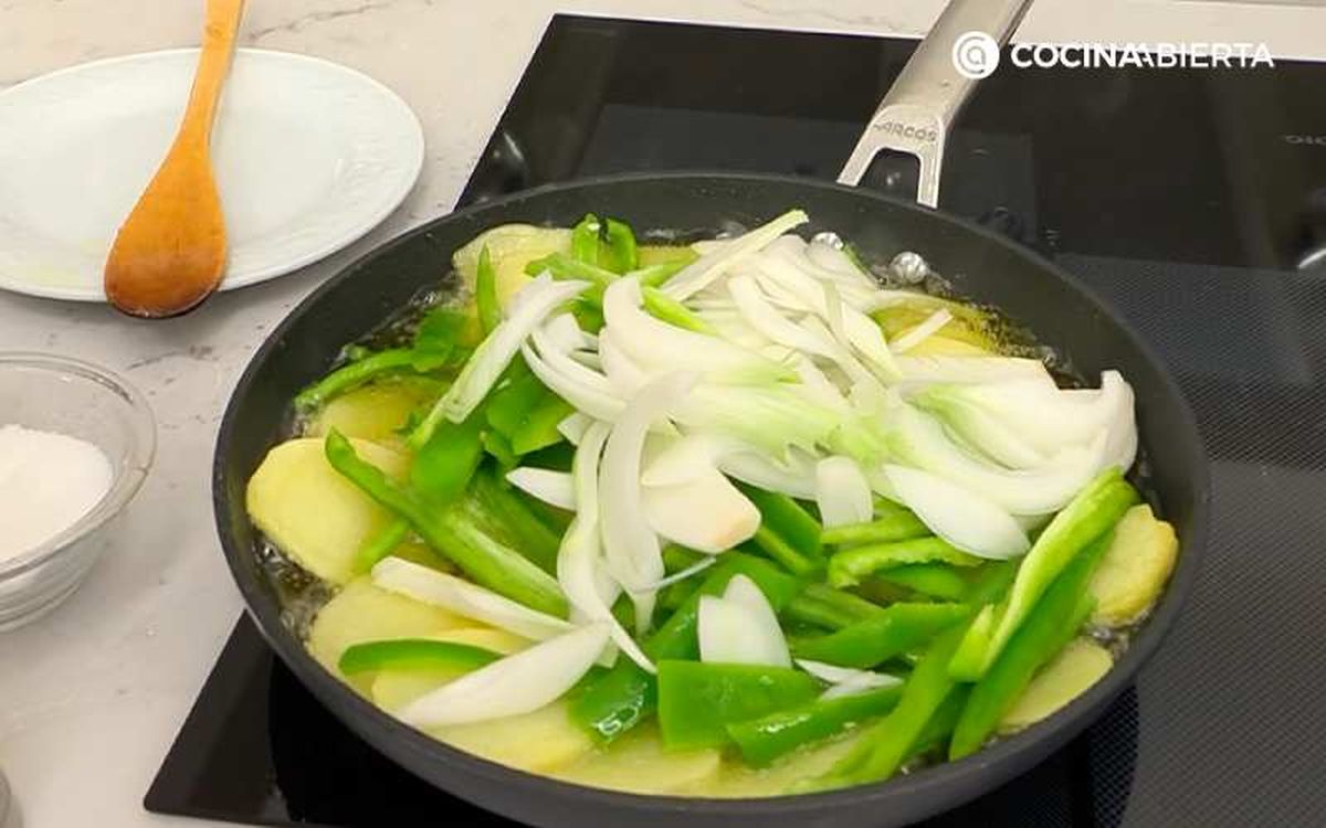 Fríe las patatas con las cebolletas y los pimientos