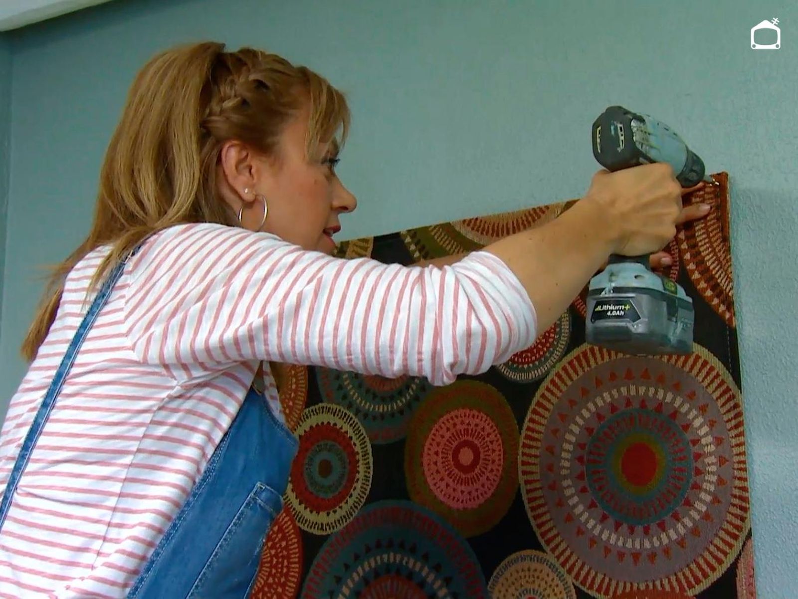 Colocando una alfombra para decorar la pared de un dormitorio de estudiante.